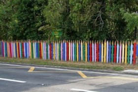 Забор в виде цветных карандашей создается из бревен или даже досок, которые обрезаются сверху по виду заточки и просто окрашиваются в разные цвета